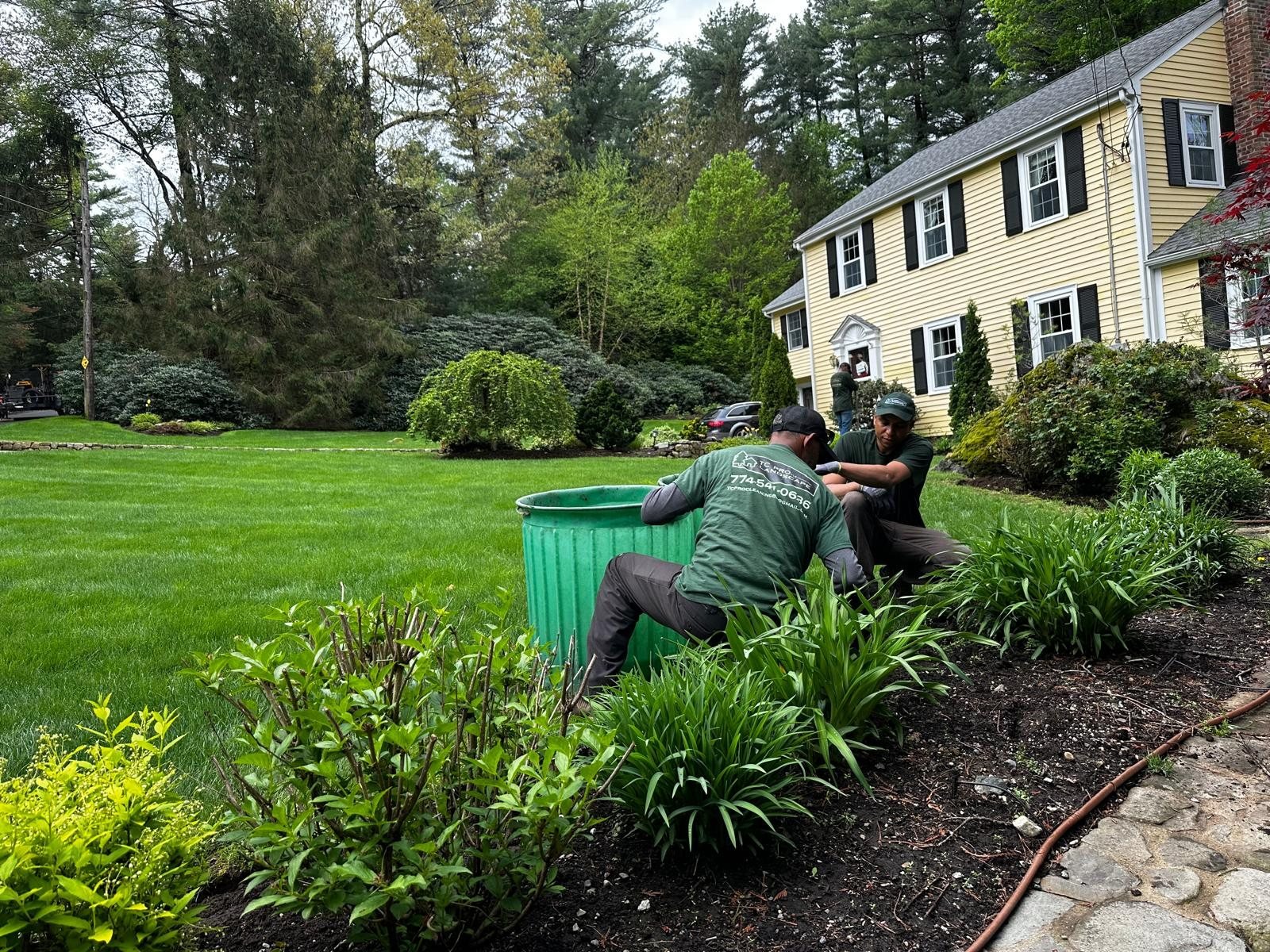 Two crew members working in a bed in front of a yellow colonial